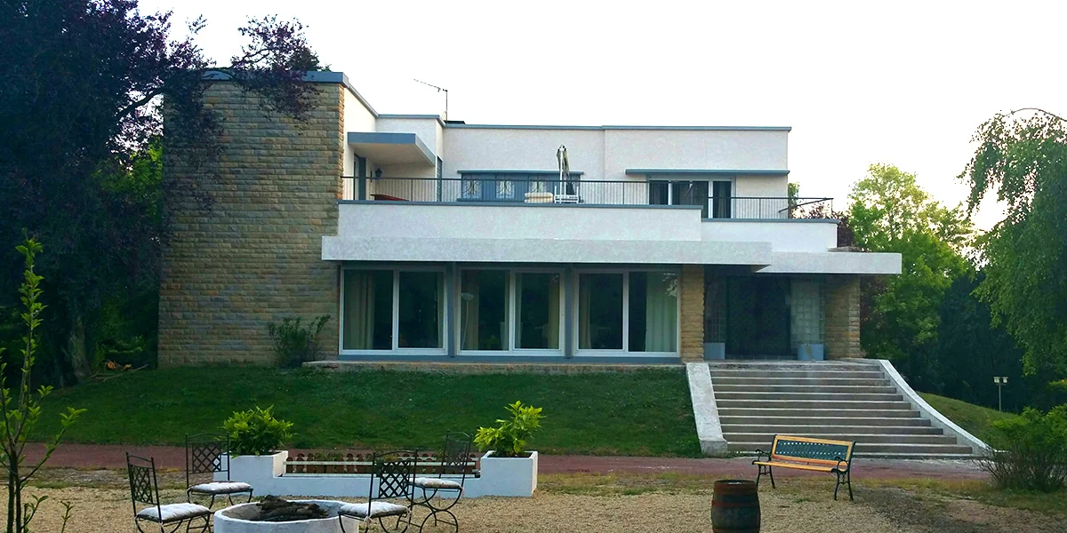 Maison contemporaine blanche associant enduit et parement en pierre